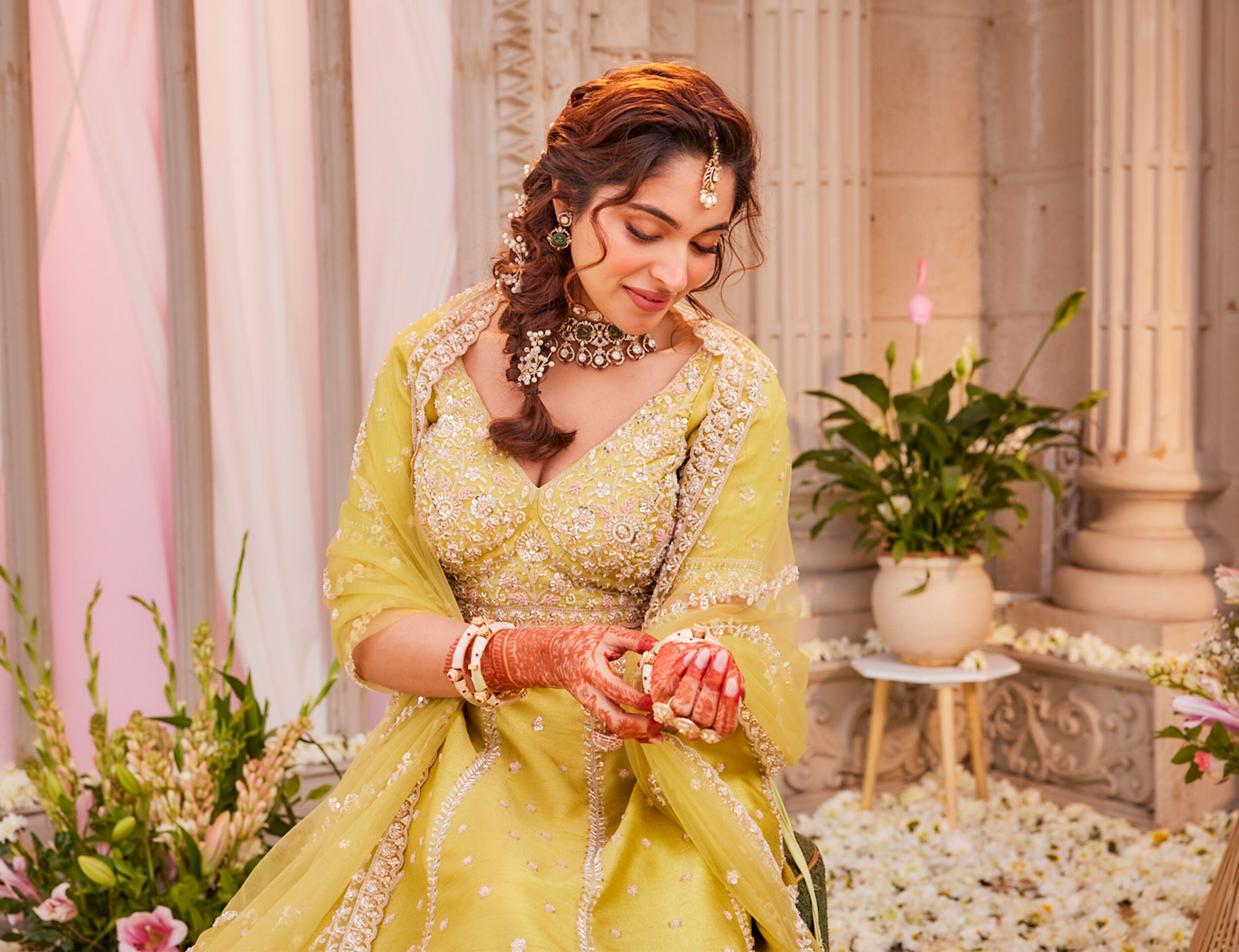 Woman wearing a vibrant yellow lehenga for a Mehendi function celebration